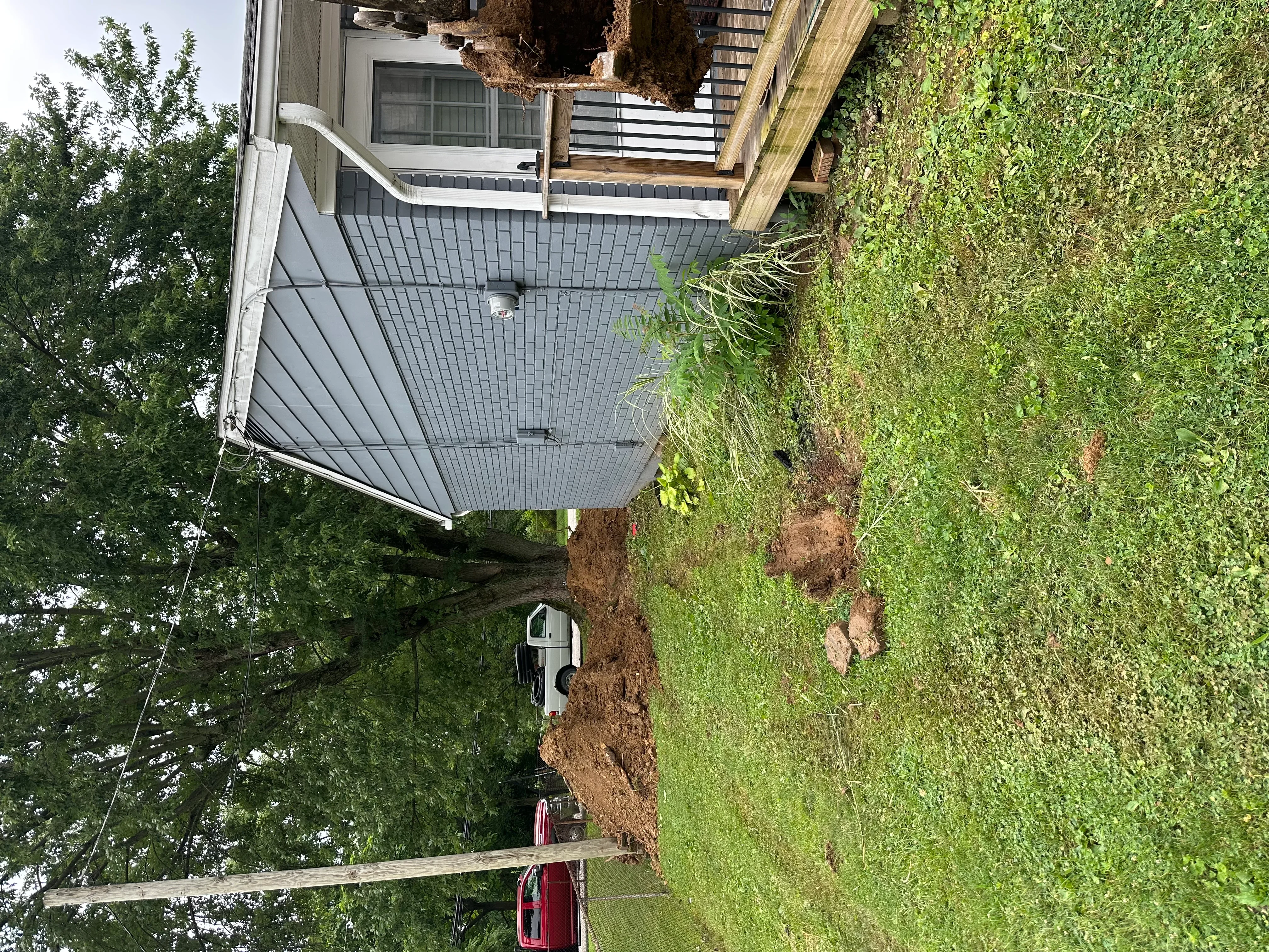 Residential lot with freshly graded driveway area and excavated soil preparation