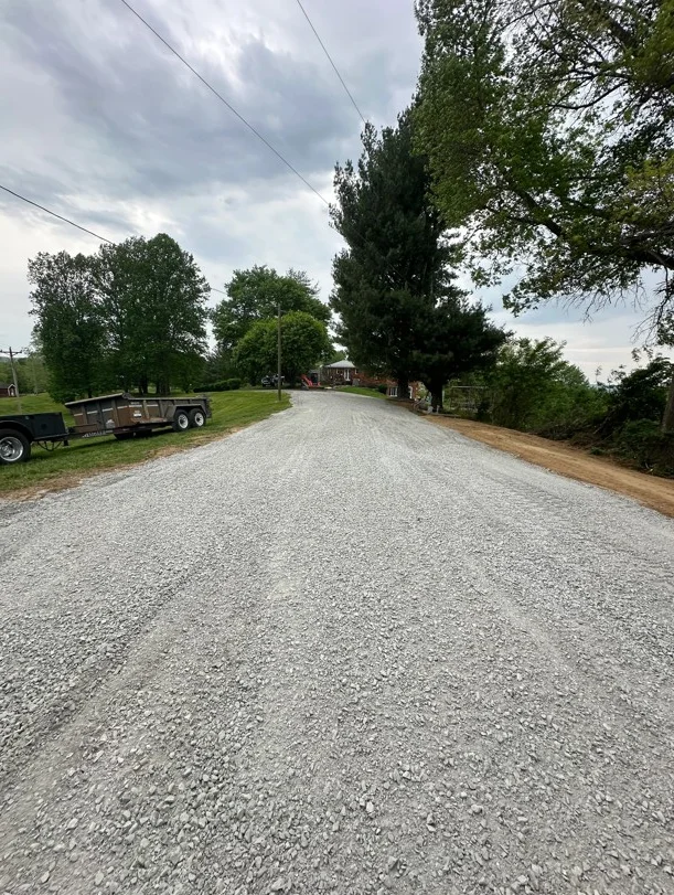 Newly installed gravel driveway with compacted crushed stone surface on rural property