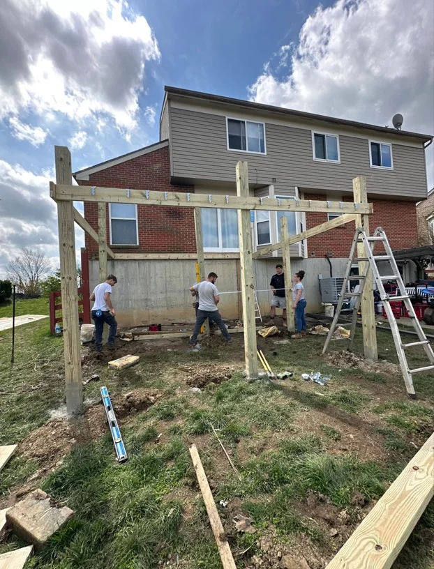 Deck foundation excavation with timber framing, concrete footings, and site grading in progress