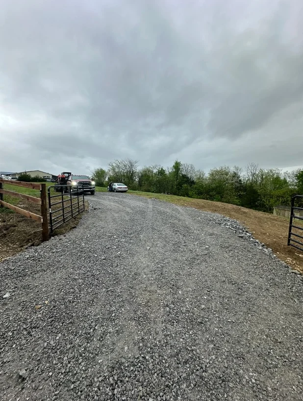 Gravel driveway with metal gates and compacted stone base