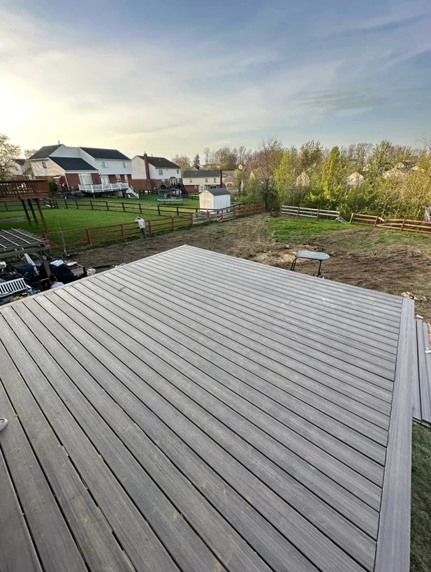 Gray composite deck with white trim and railing overlooking rural property