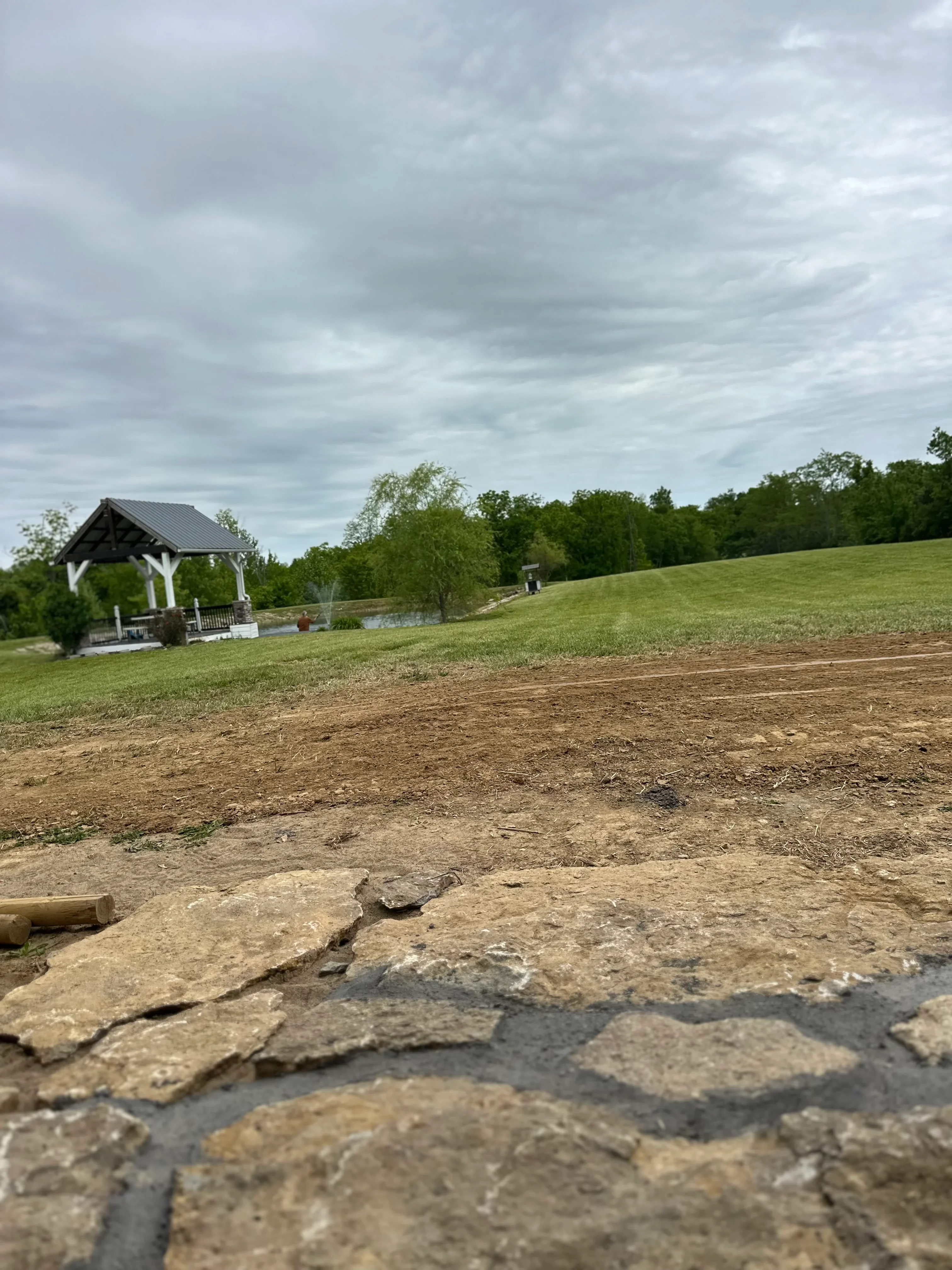Excavated driveway base with compacted soil and grading work on residential property