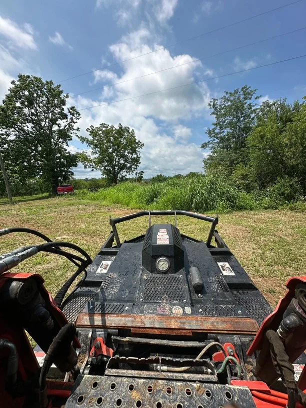 Excavation equipment on cleared land with graded soil and removed vegetation