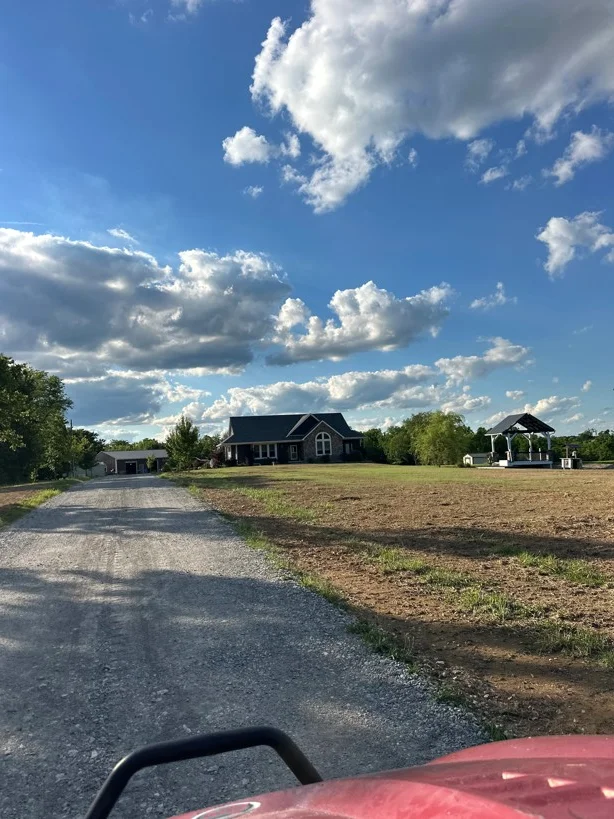 Gravel driveway with crushed stone surface leading to residential home with garage
