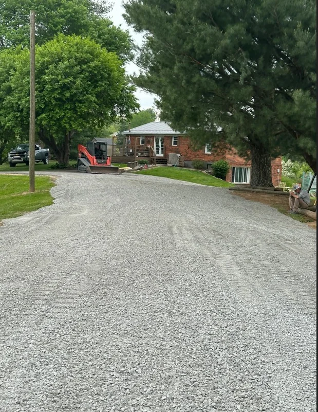 Newly installed gravel driveway with compacted stone base and proper drainage slope